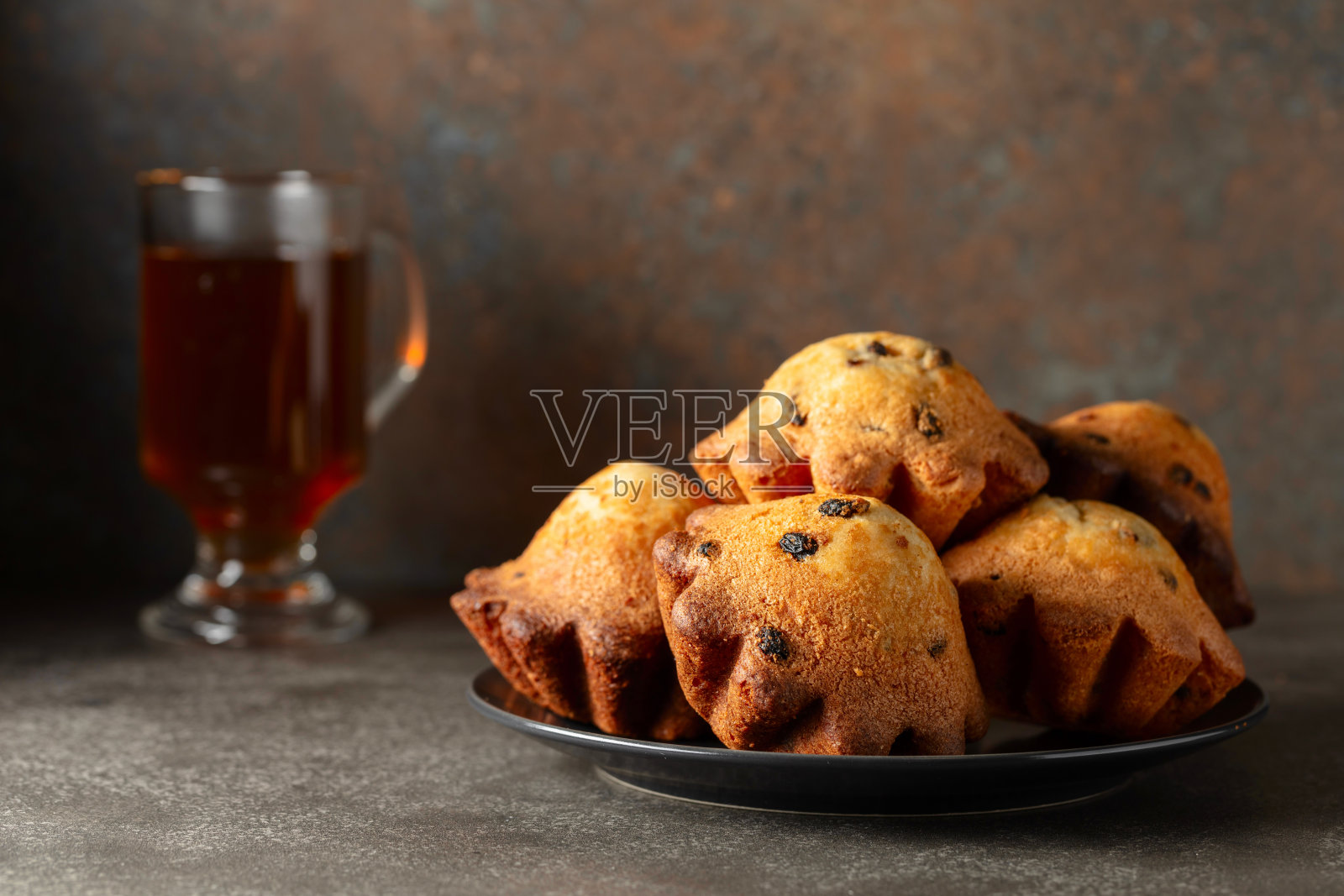 自制葡萄干小蛋糕和一杯茶。照片摄影图片