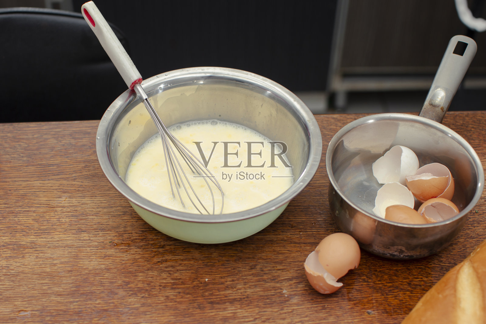 碗里有做煎蛋卷的混合物和做鸡蛋的壳。照片摄影图片