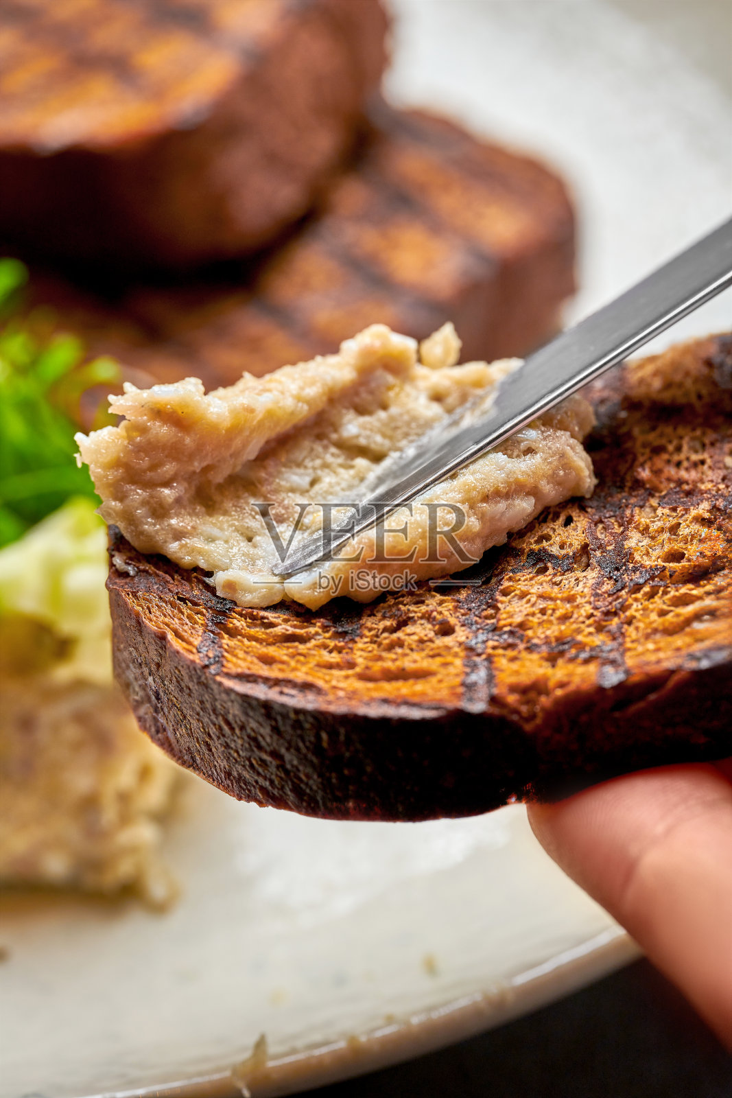 在烤面包上涂上鲱鱼肉照片摄影图片