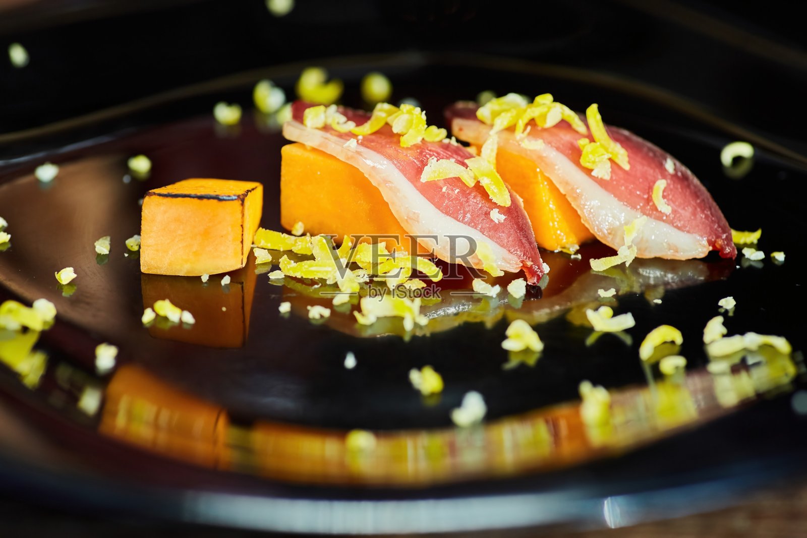 两片烤南瓜上放上烤好的烤肉片,撒上帕尔马干酪。一步一步地创造一道美丽的菜肴。食物的风格照片摄影图片