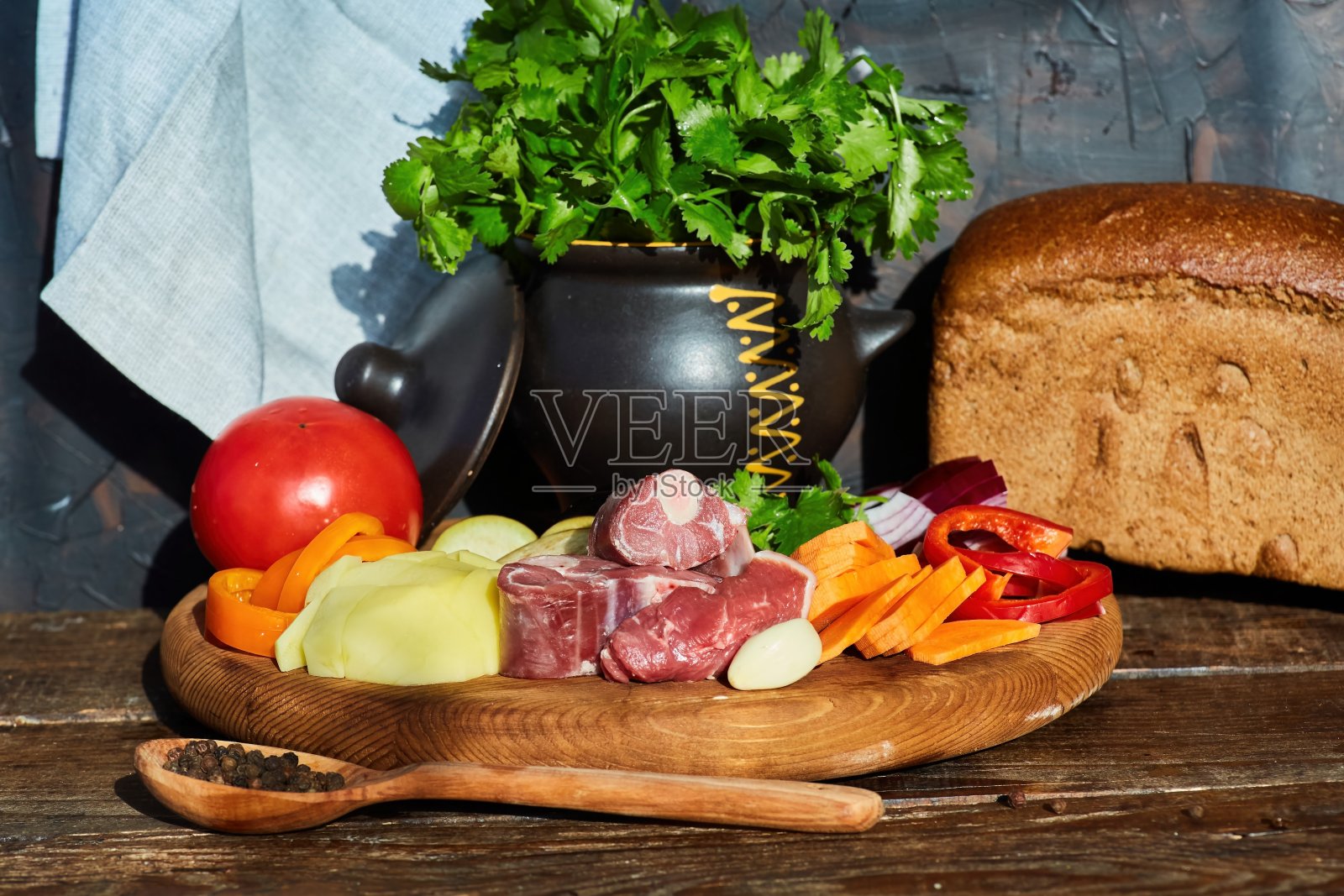 木桌上放着几块生猪肉,周围是用来做罗宋汤和其他菜的蔬菜。肉类生产照片摄影图片