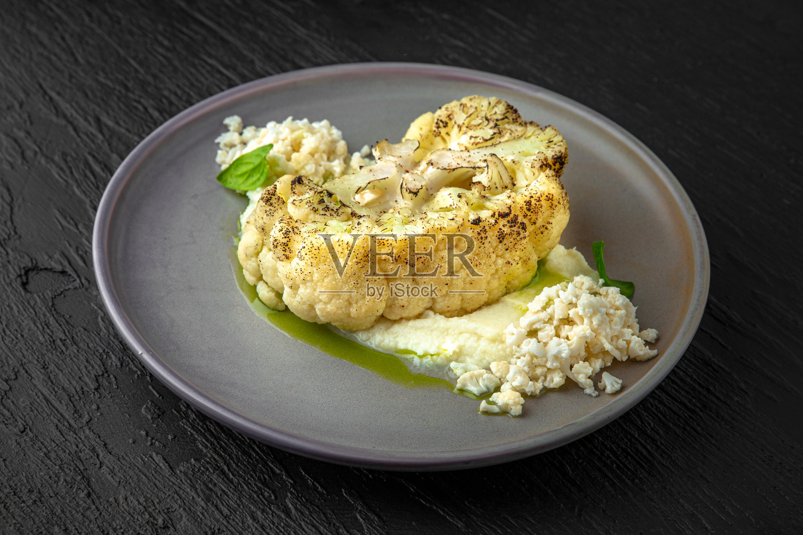 不丰盛的菜单。花椰菜牛排在绿色酱在一个陶瓷盘子在黑暗纹理的背景。餐厅的菜单照片摄影图片