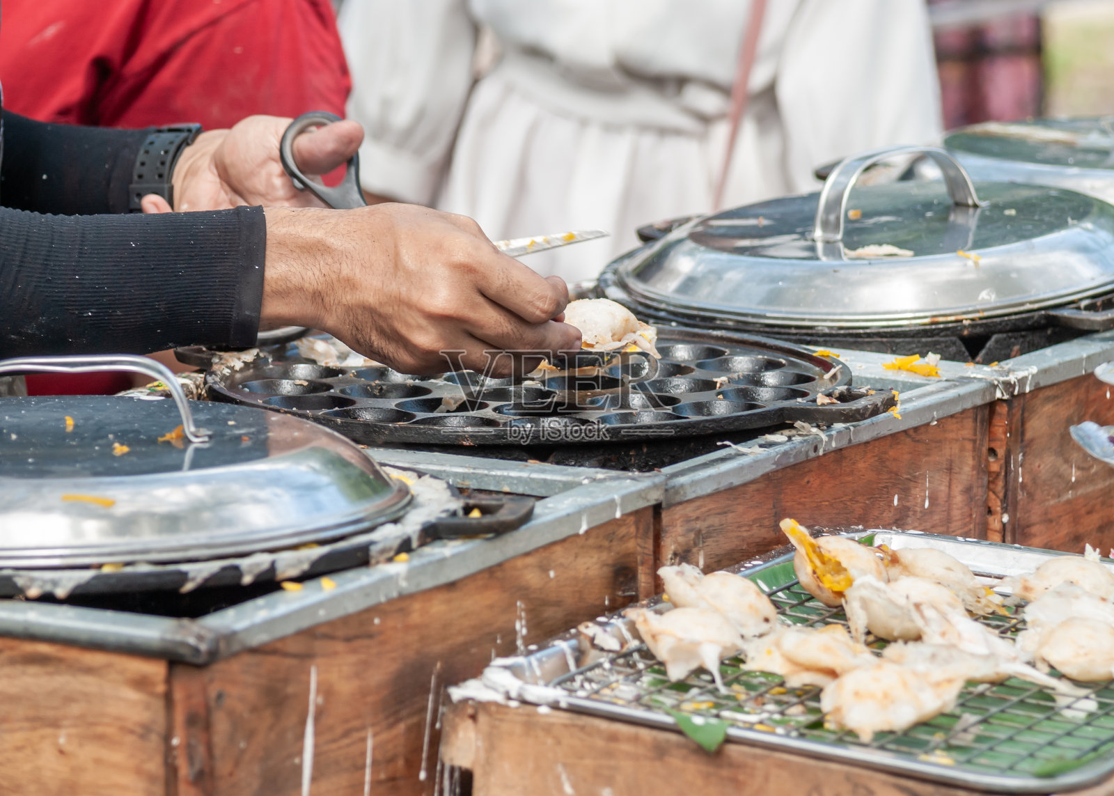 泰式煎饼,男手制作的khanom krok是泰国传统的美味甜点照片摄影图片