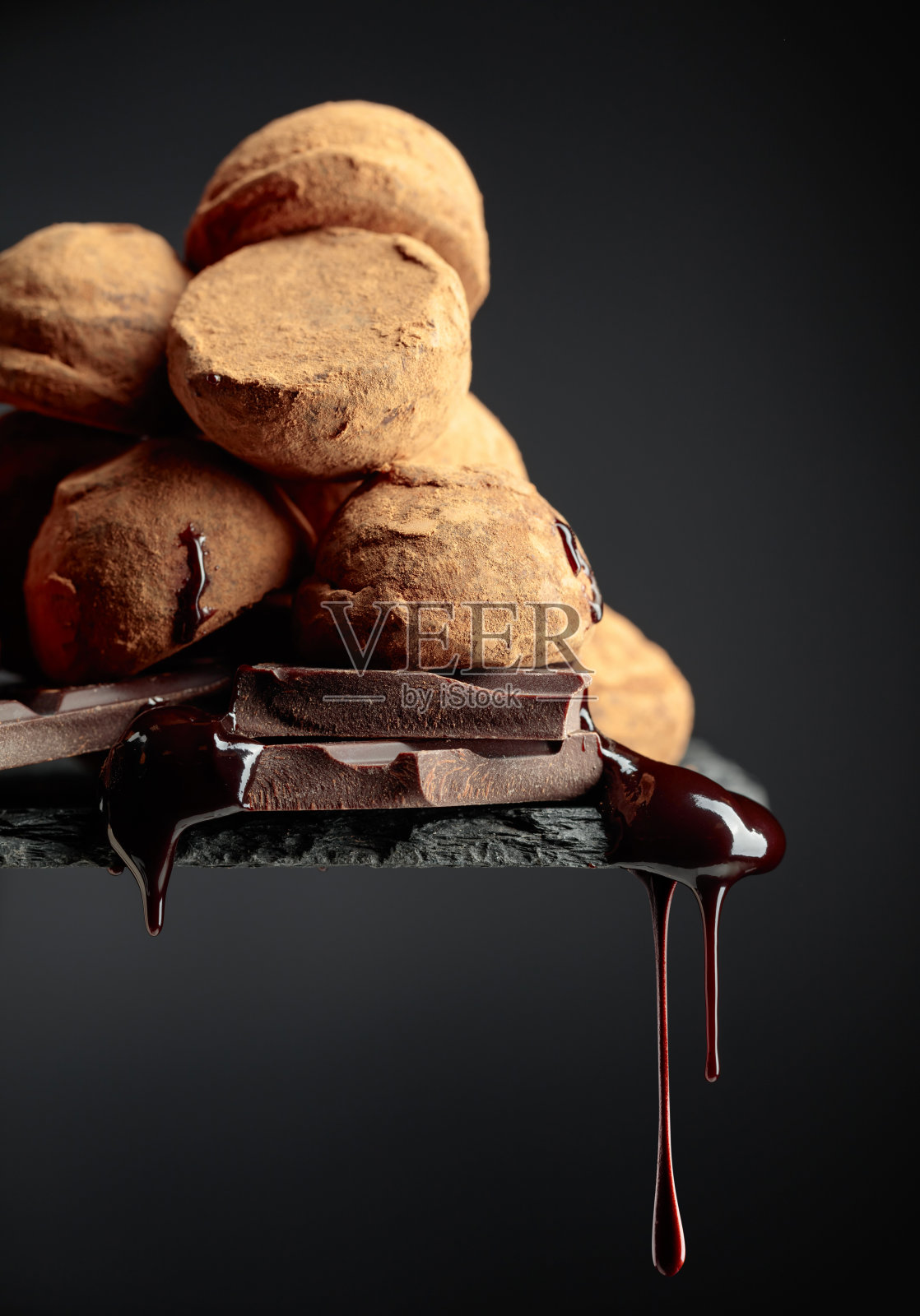 巧克力松露和落下的巧克力酱。照片摄影图片