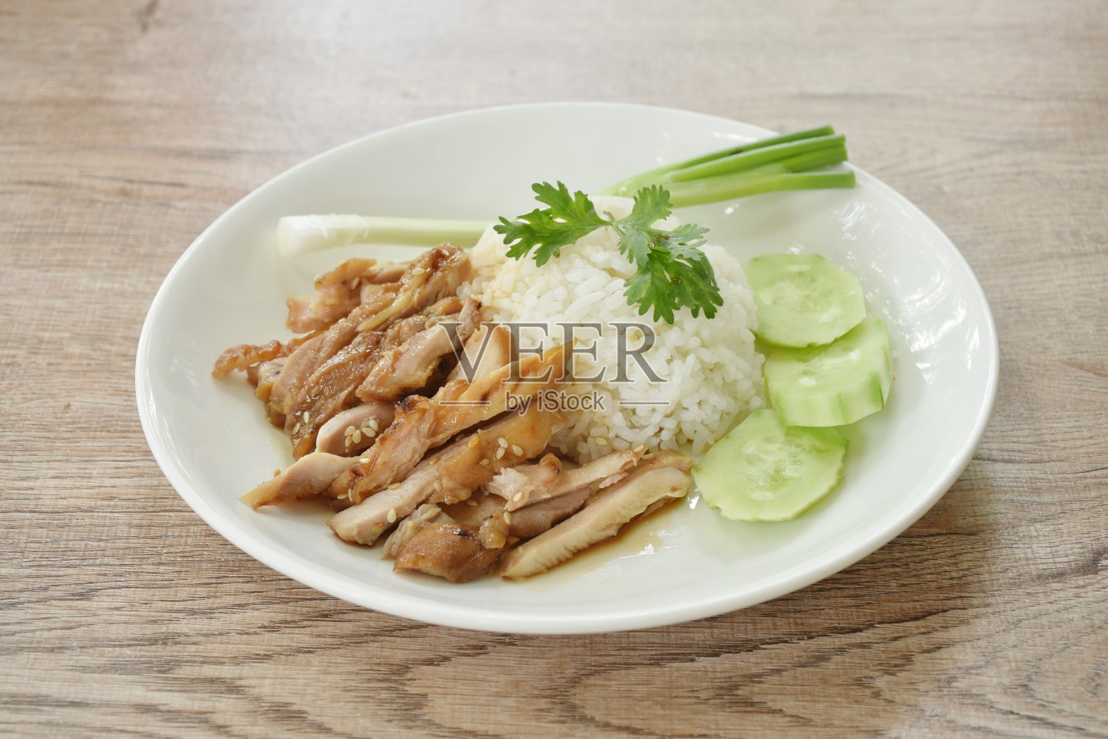 将烤鸡切片,配以白芝麻和照烧日本酱,配以黄瓜和葱照片摄影图片