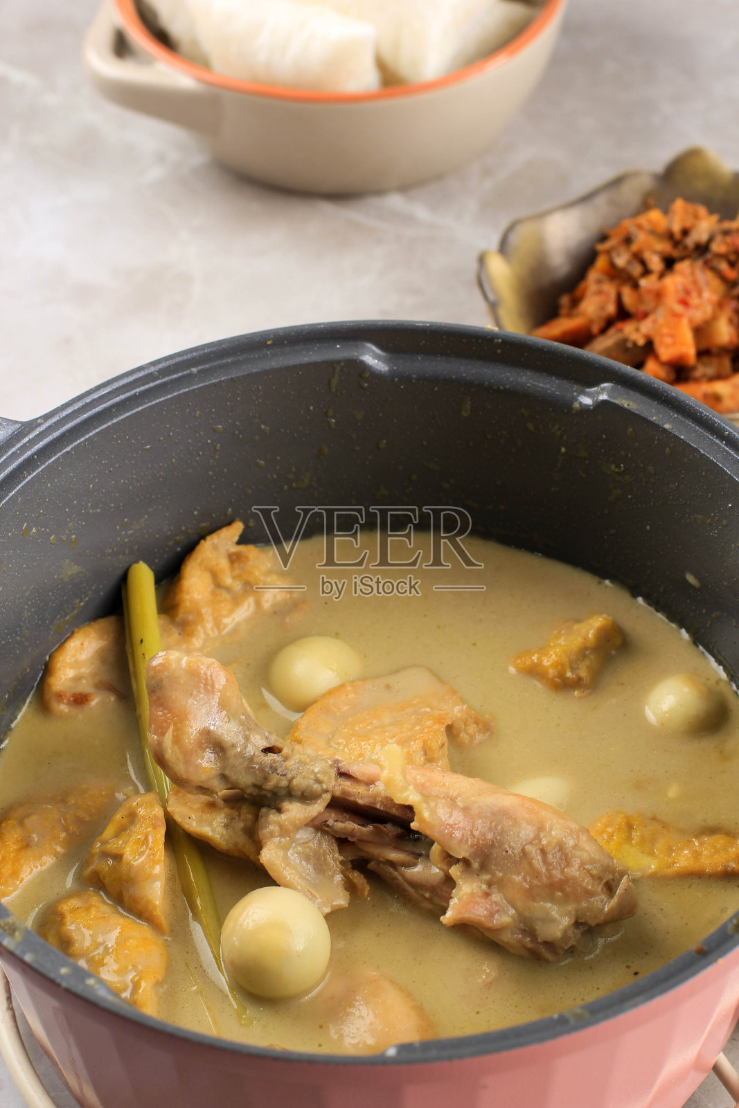 用豆腐和鹌鹑蛋烹饪印尼咖喱鸡,厨房里的烹饪过程。煮熟的照片摄影图片