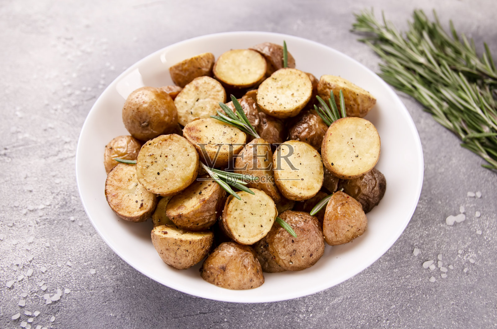 美味的烤土豆和迷迭香在灰色的背景照片摄影图片