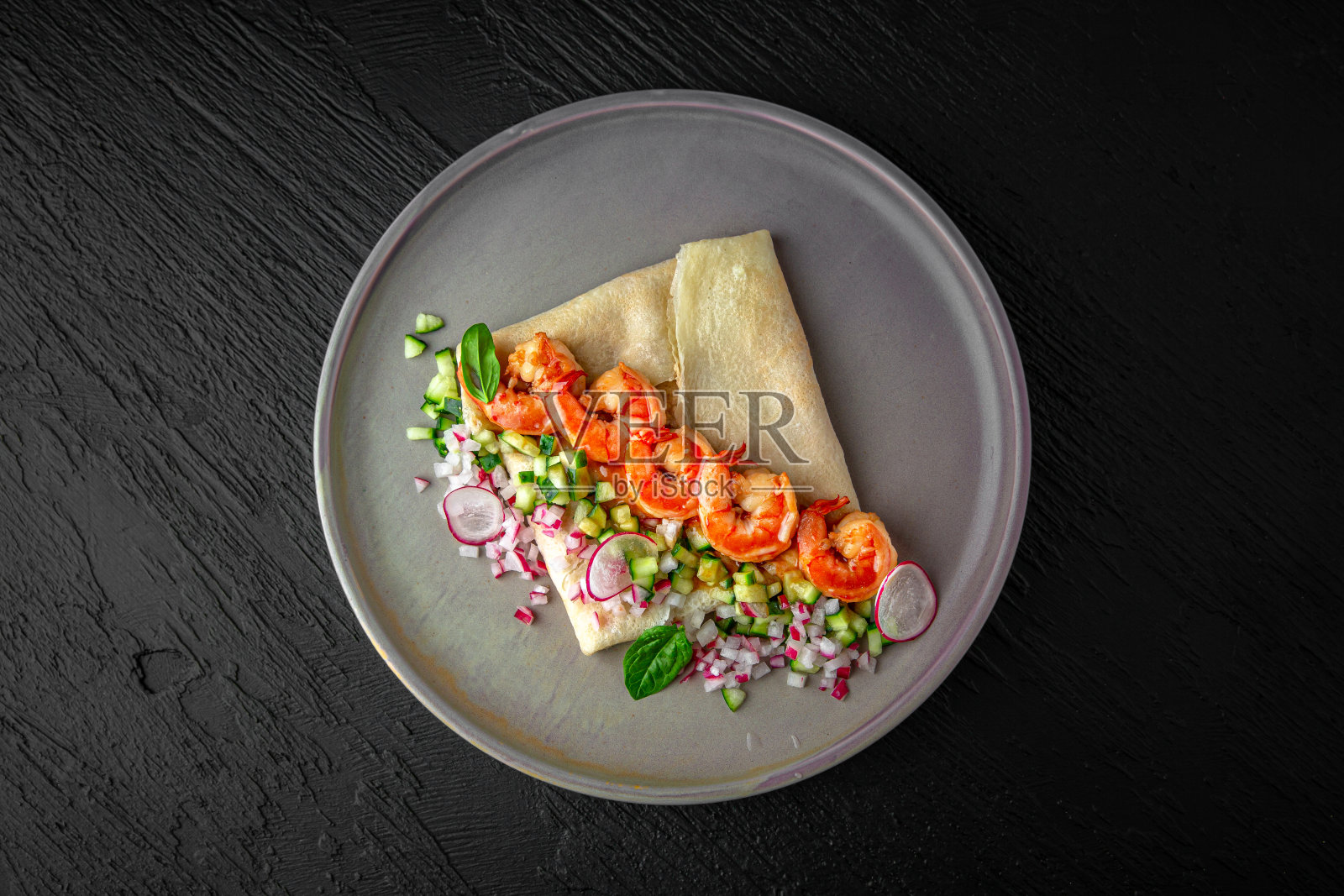 米粉煎饼、豆腐和虾放在陶瓷盘子里,背景是深色纹理。餐厅的菜单照片摄影图片