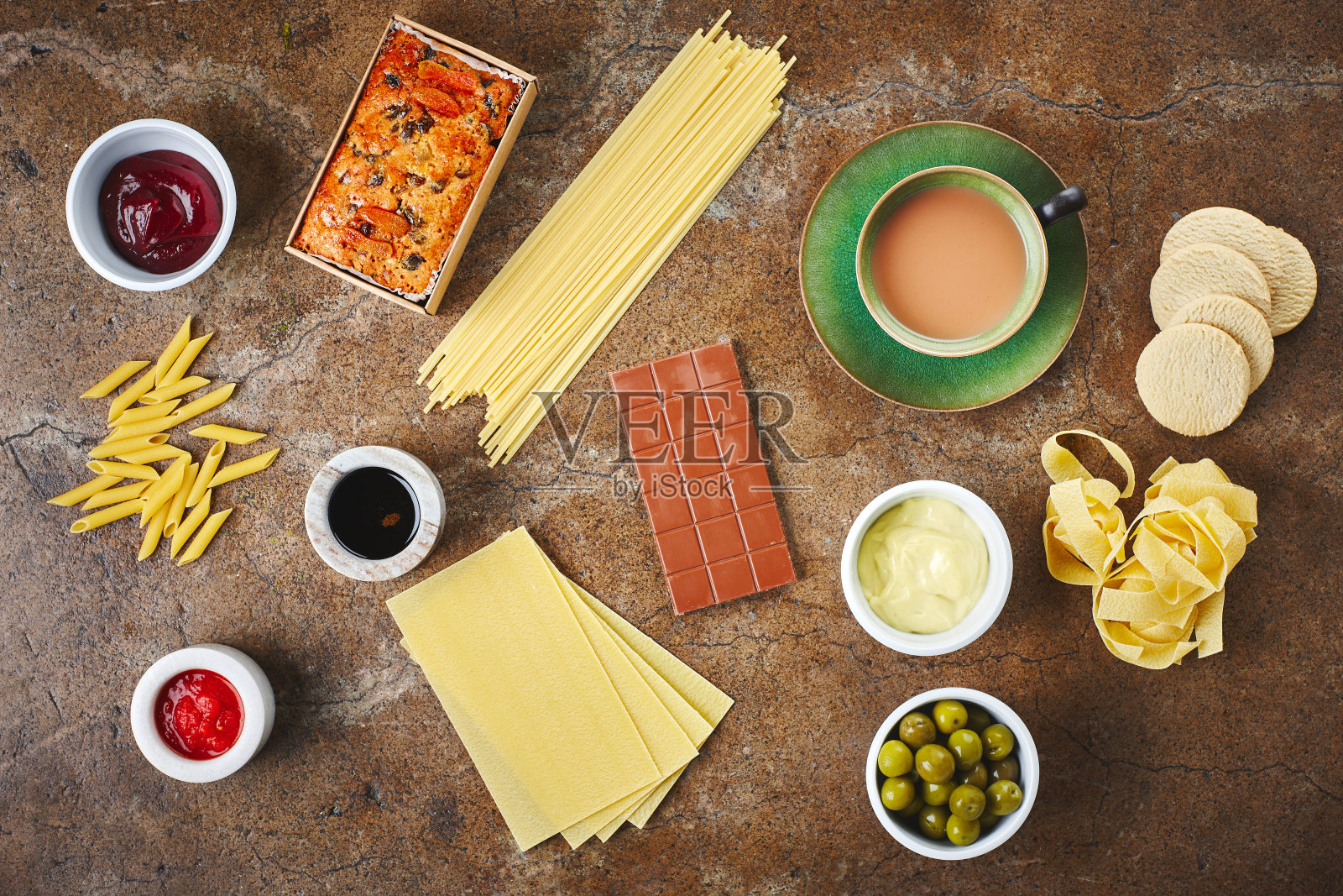 在厨房用面条,酱汁和罐子做饭,食物及以上的食材。意大利面,晚餐和柜台的俯视图与意大利美食的健康,营养和健康的饮食照片摄影图片
