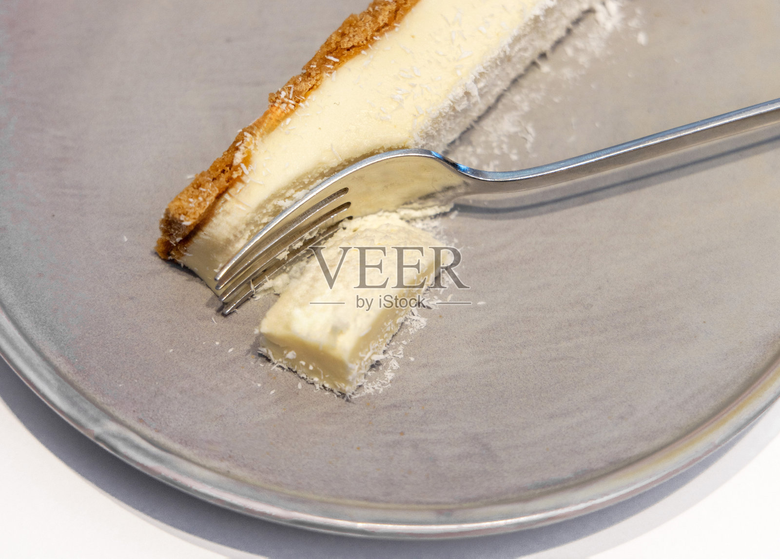 白色背景的切盘刀上的芝士蛋糕照片摄影图片