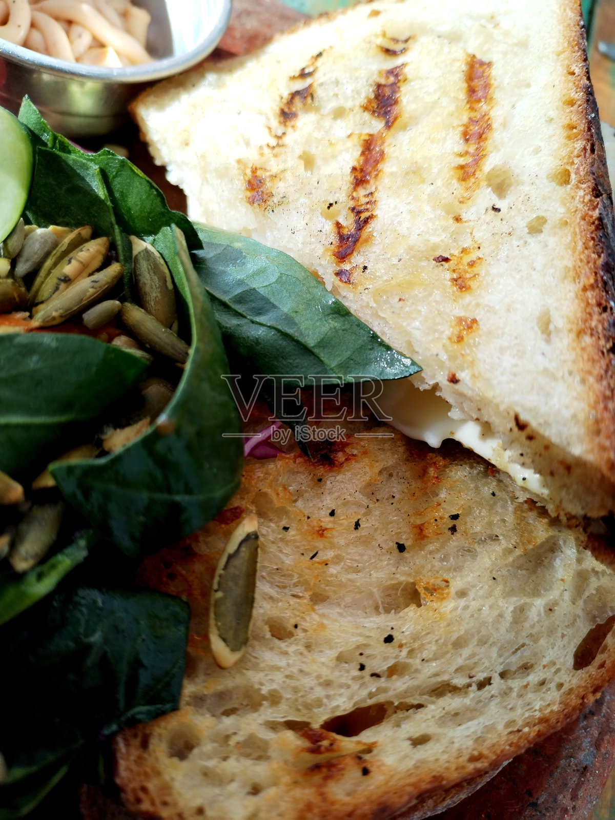 烤奶酪三明治配酸面包和配菜沙拉生菜,黄瓜籽和墨西哥辣酱照片摄影图片