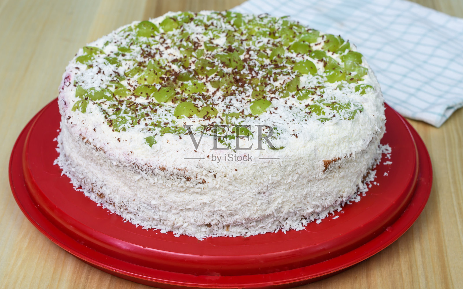 自制的圆形白色椰子蛋糕,配上葡萄照片摄影图片