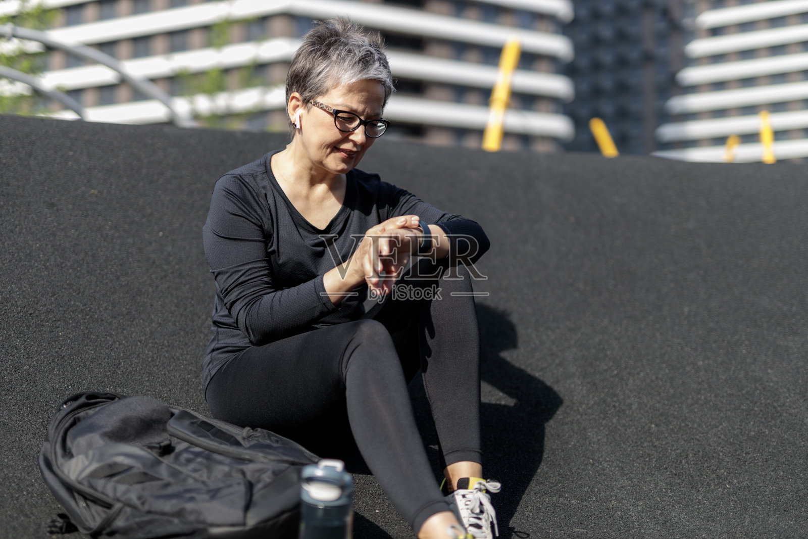 成熟的女人喜欢户外健身,用手表,准备跑步。照片摄影图片