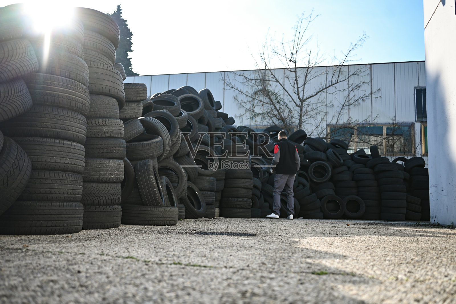 在汽车修理店修理汽车轮胎的男子。填埋旧轮胎照片摄影图片