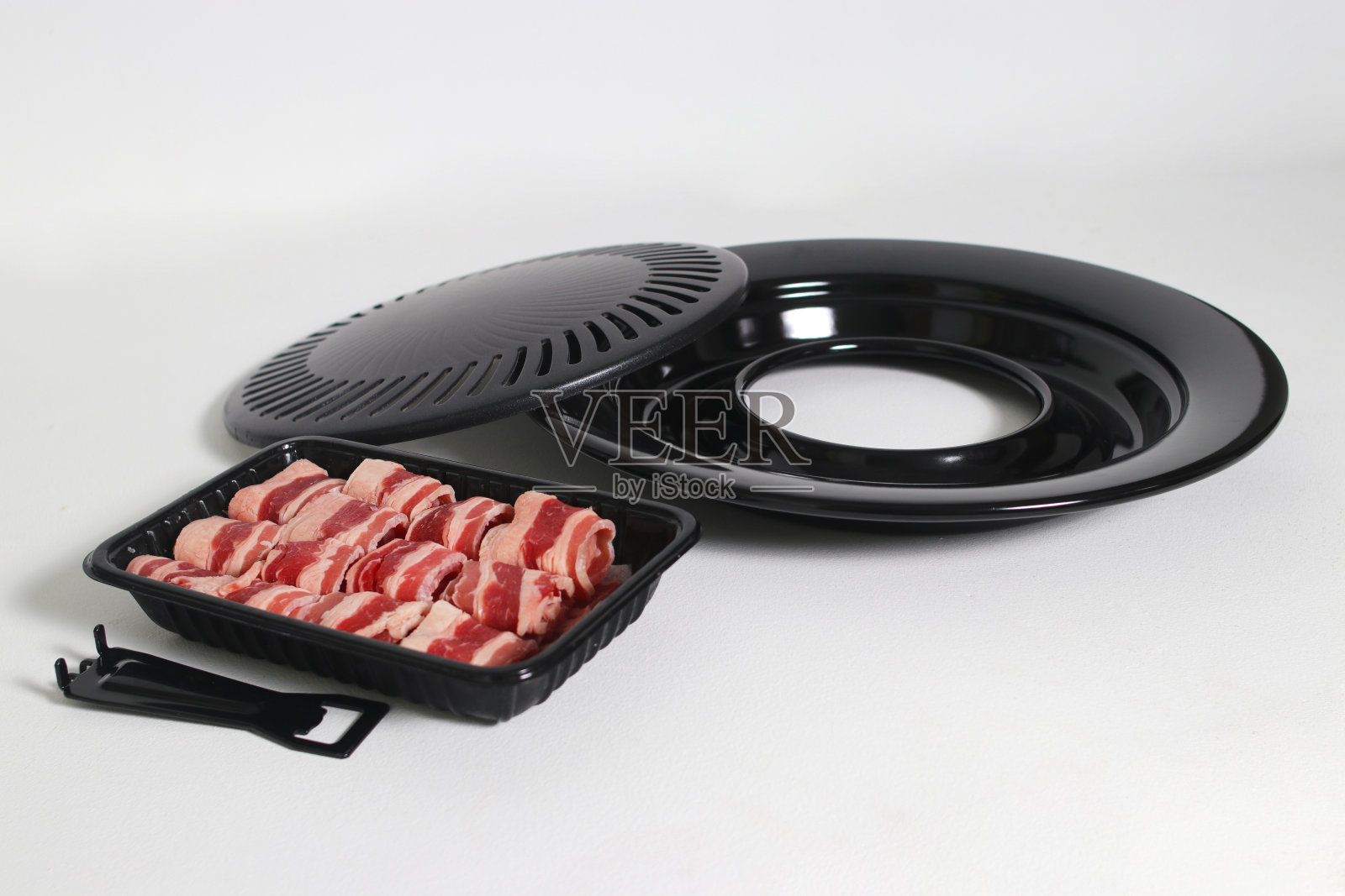 白色背景的烤盘上放着生牛肉片照片摄影图片