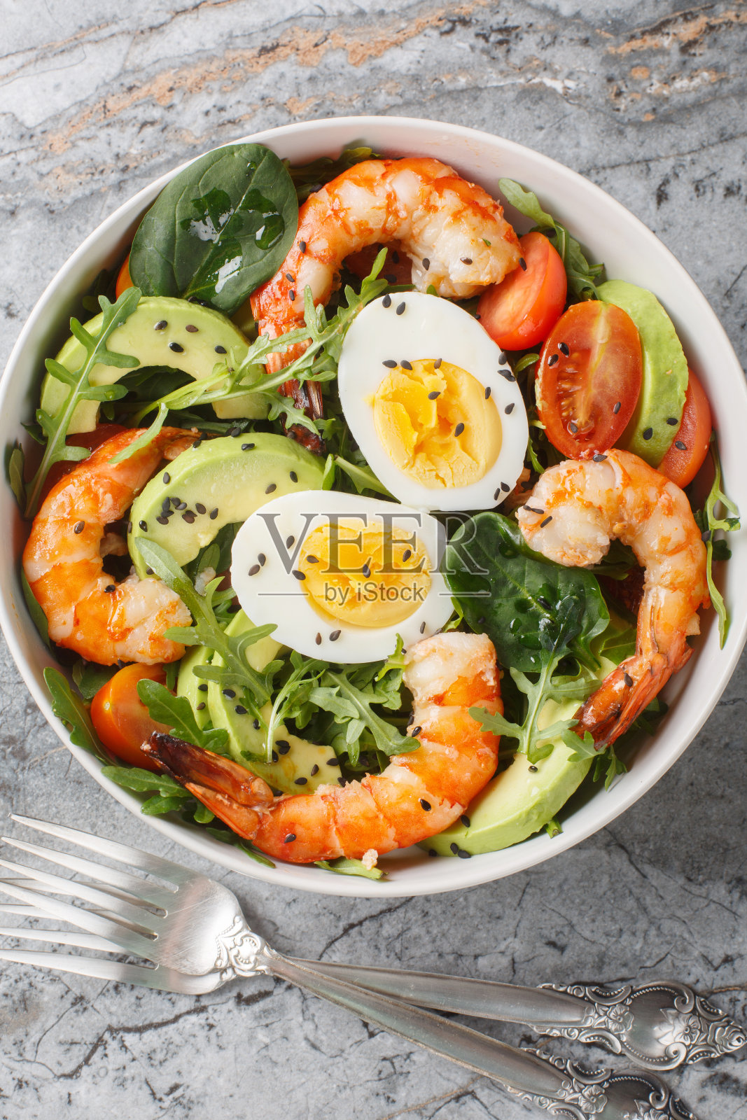 用虎虾、鳄梨、芝麻菜、菠菜、西红柿和芝麻做成的减肥沙拉。垂直俯视图照片摄影图片