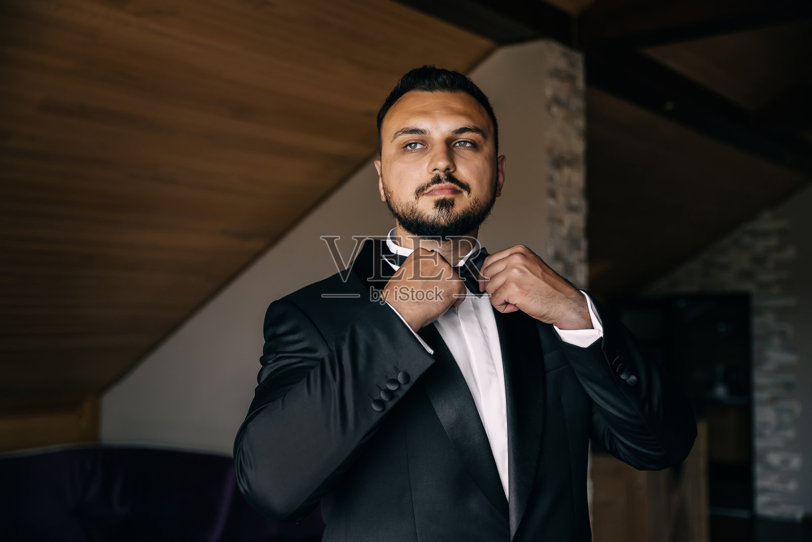 沉思的男人整理领带。为婚礼做好准备。照片摄影图片