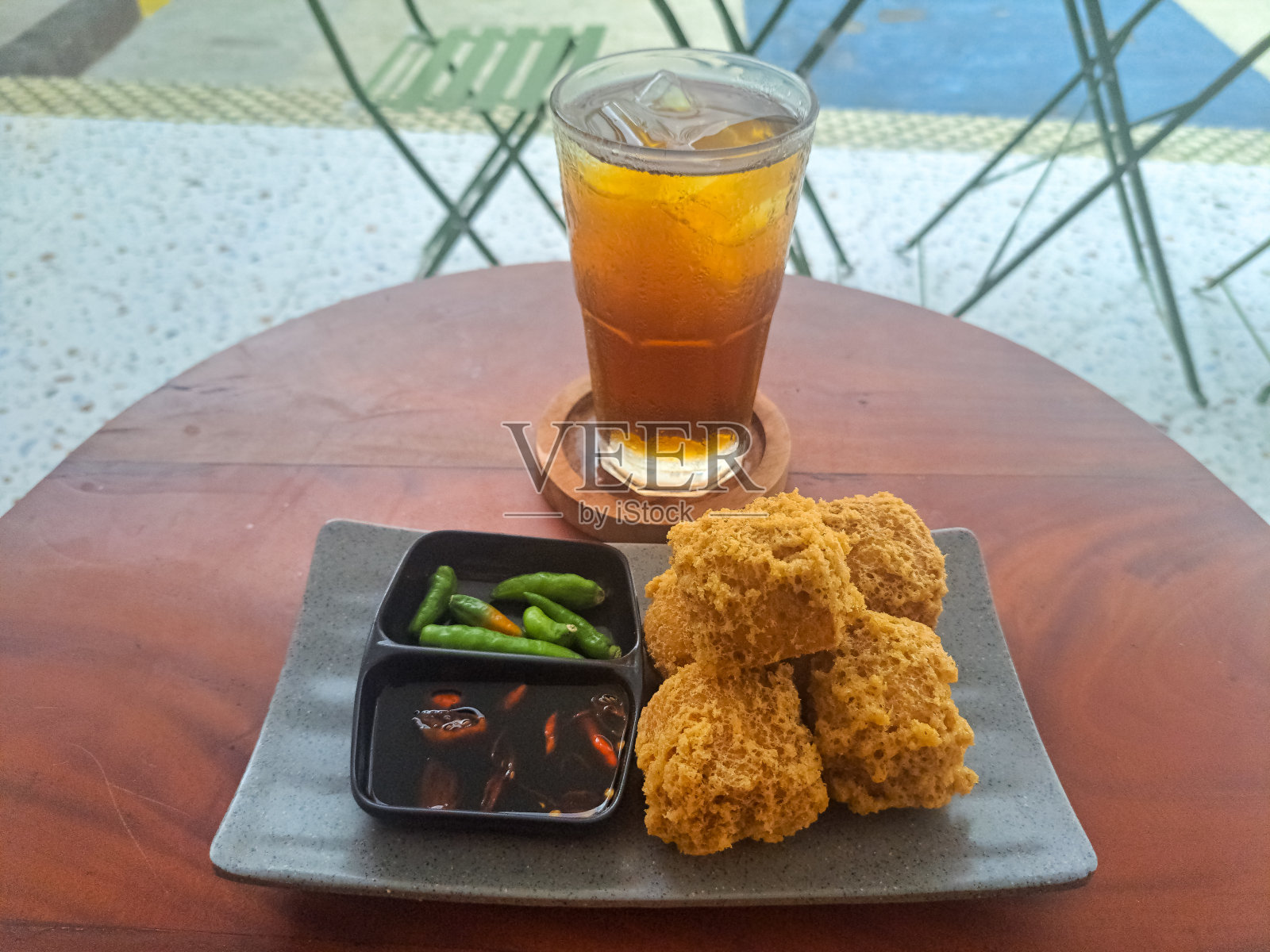 美味的Tahu Goreng Krispi或炸豆腐脆和茶冰(Es Teh)。零食和饮料菜单。照片摄影图片