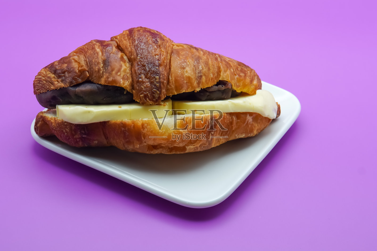 特写新鲜羊角面包。亮紫色背景照片摄影图片