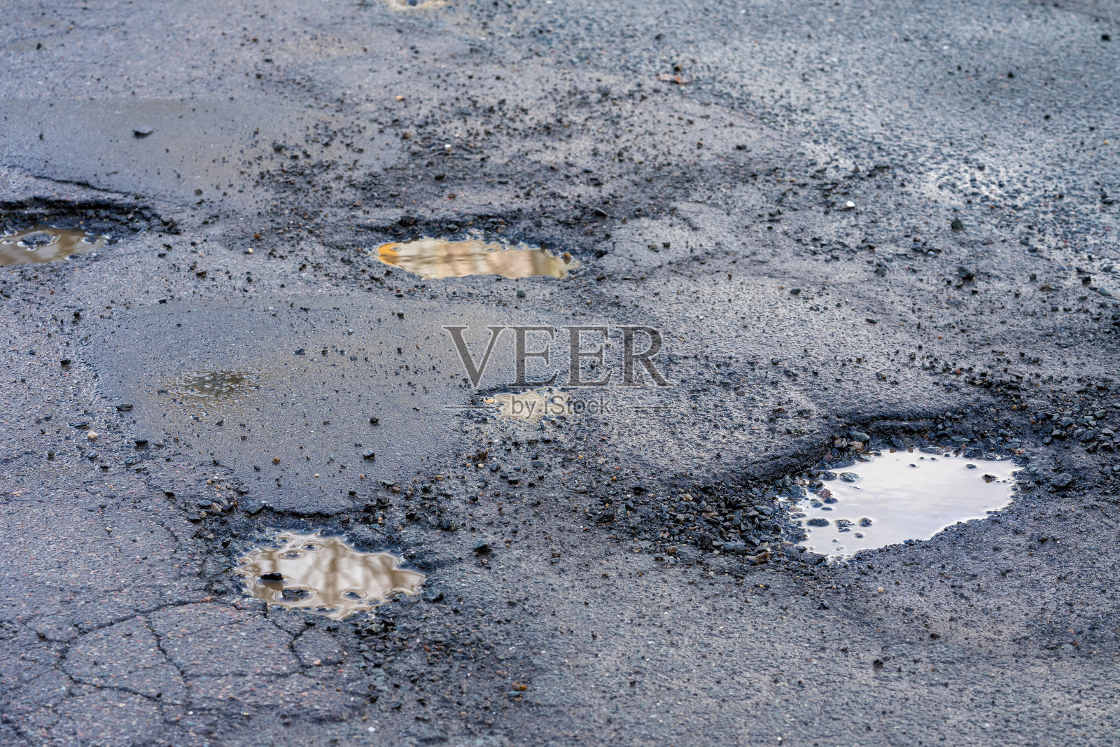 春天冬天霜冻后的路面上的坑洼照片摄影图片