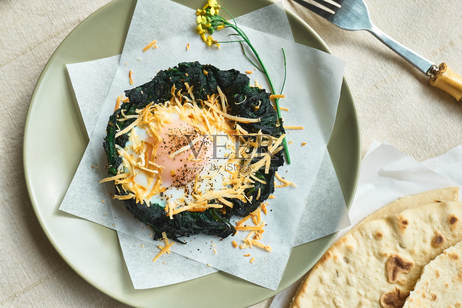 复活节早餐的主意。用磨碎的奶酪和黑胡椒装饰的烤菠菜蛋巢。节日的食物。孩子们有趣的健康食品。照片摄影图片