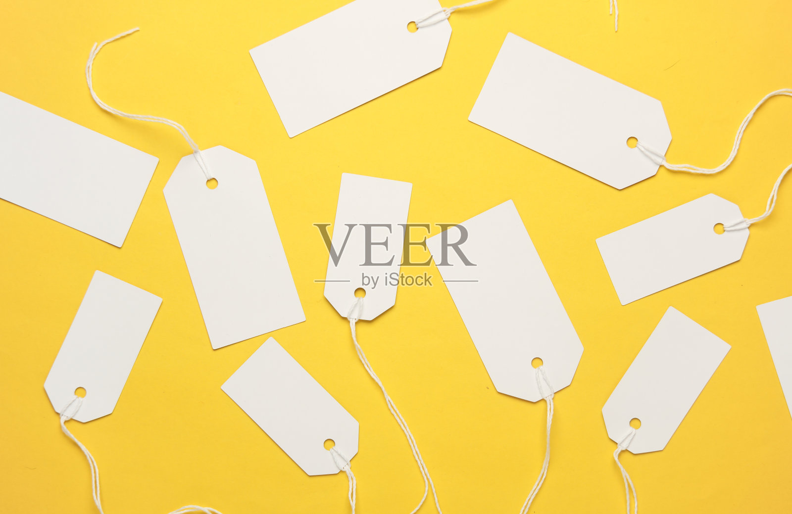 黄色背景上有绳索的空白白色标签。模拟,模板的设计。副本的空间。销售、购物理念照片摄影图片