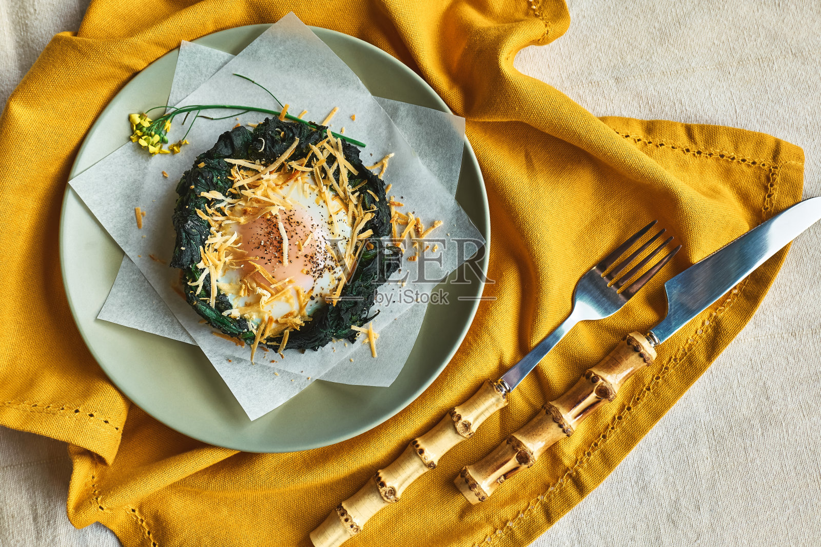 复活节早餐的主意。用磨碎的奶酪和黑胡椒装饰的烤菠菜蛋巢。节日的食物。孩子们有趣的健康食品。照片摄影图片