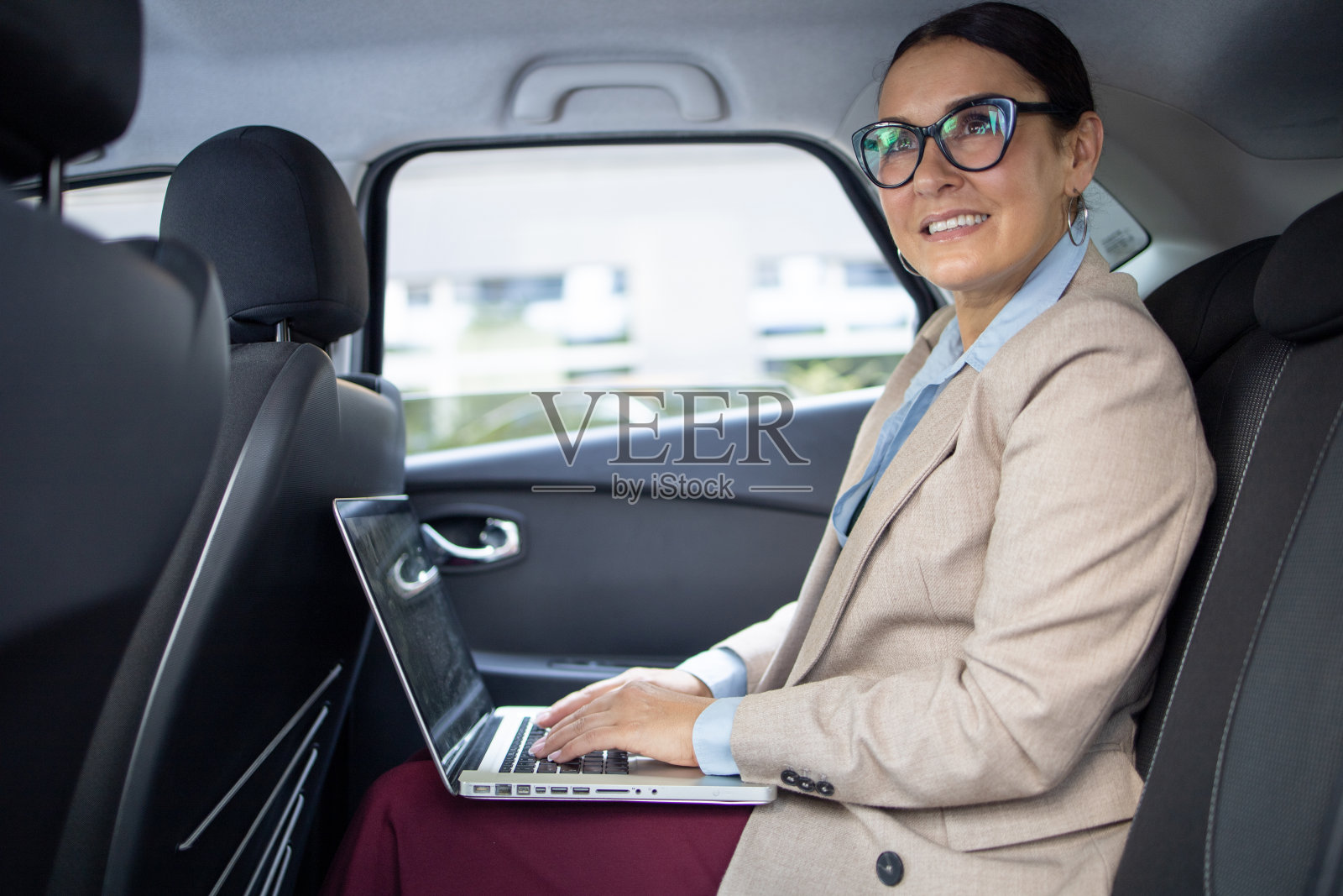 一个女人坐在汽车的后座上照片摄影图片