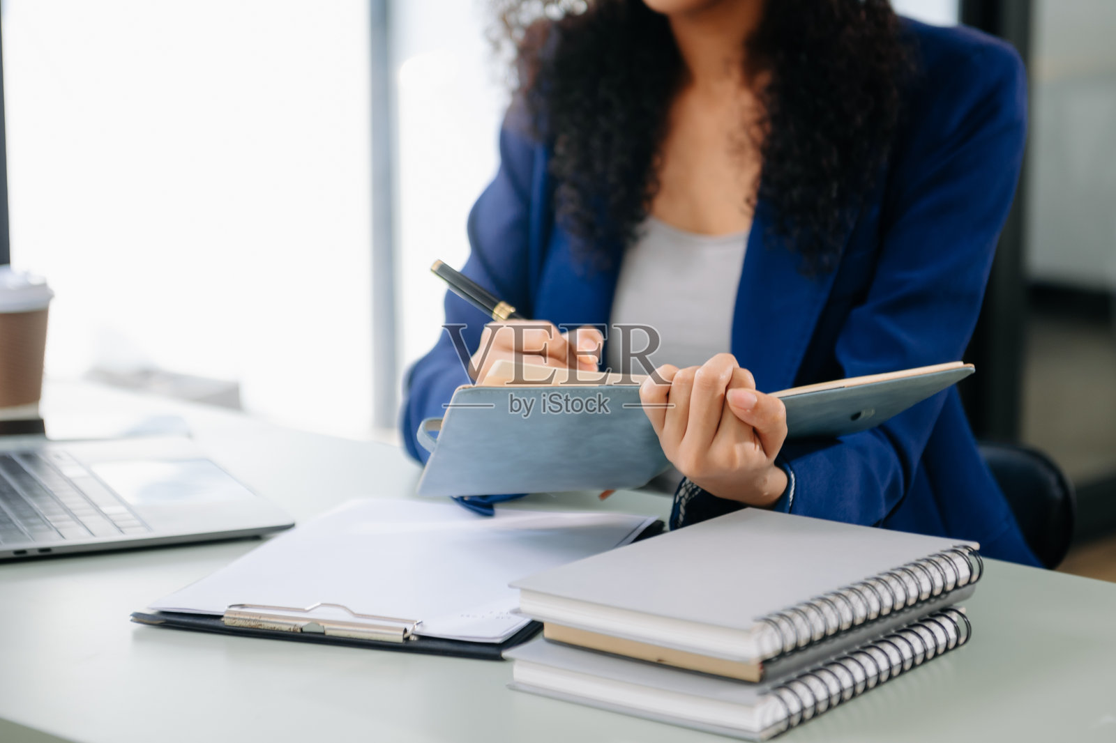 自信的商业专家迷人的微笑的年轻女子打字笔记本电脑和拿着数字平板电脑在桌子上照片摄影图片