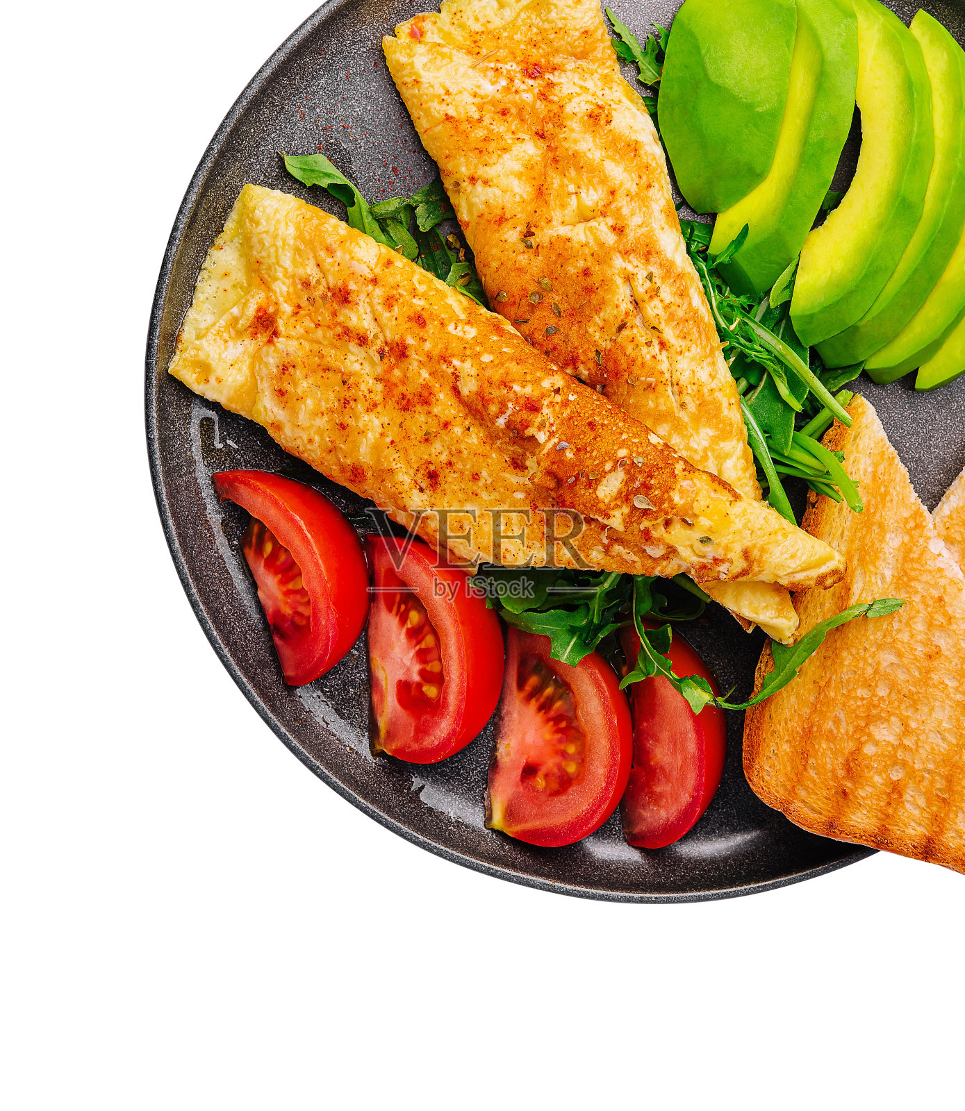 黑色陶瓷盘子上的牛油果、西红柿和芝麻菜煎蛋卷照片摄影图片