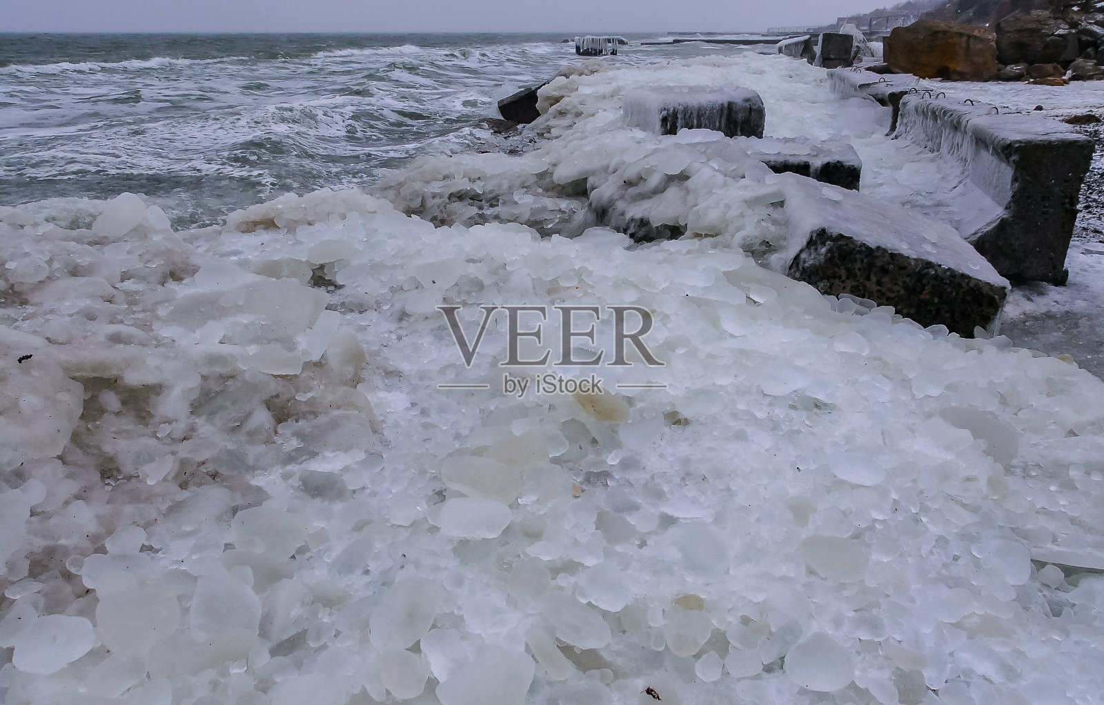 黑海结了冰,被海浪卷起的圆形冰被抛上岸并结了冰照片摄影图片