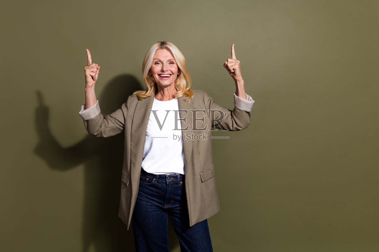 照片的职业女性经理销售b2b点手指向上推荐空白空间存款条款孤立在卡其色背景照片摄影图片