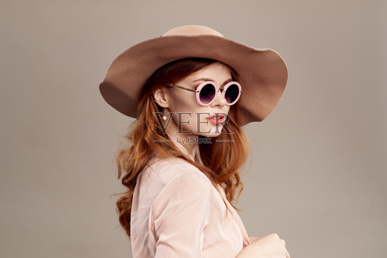 红头发的女人戴着帽子和衬衫,米色的背景化妆微笑魅力青春时尚照片摄影图片