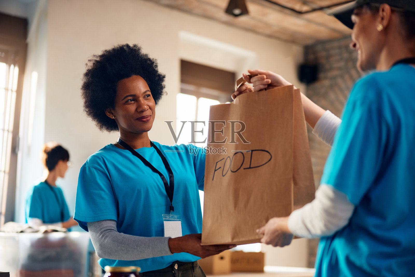 快乐的志愿者在社区中心组织食物捐赠。照片摄影图片