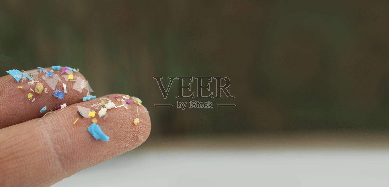 人体手指上微塑料的特写侧影。纳米塑料污染的概念。照片摄影图片