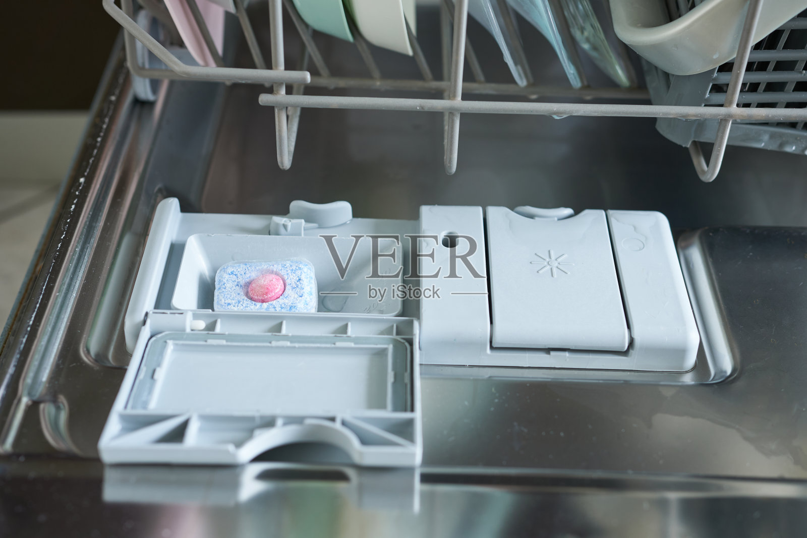 打开门的洗碗机,特写视图。洗涤剂舱,特写。照片摄影图片