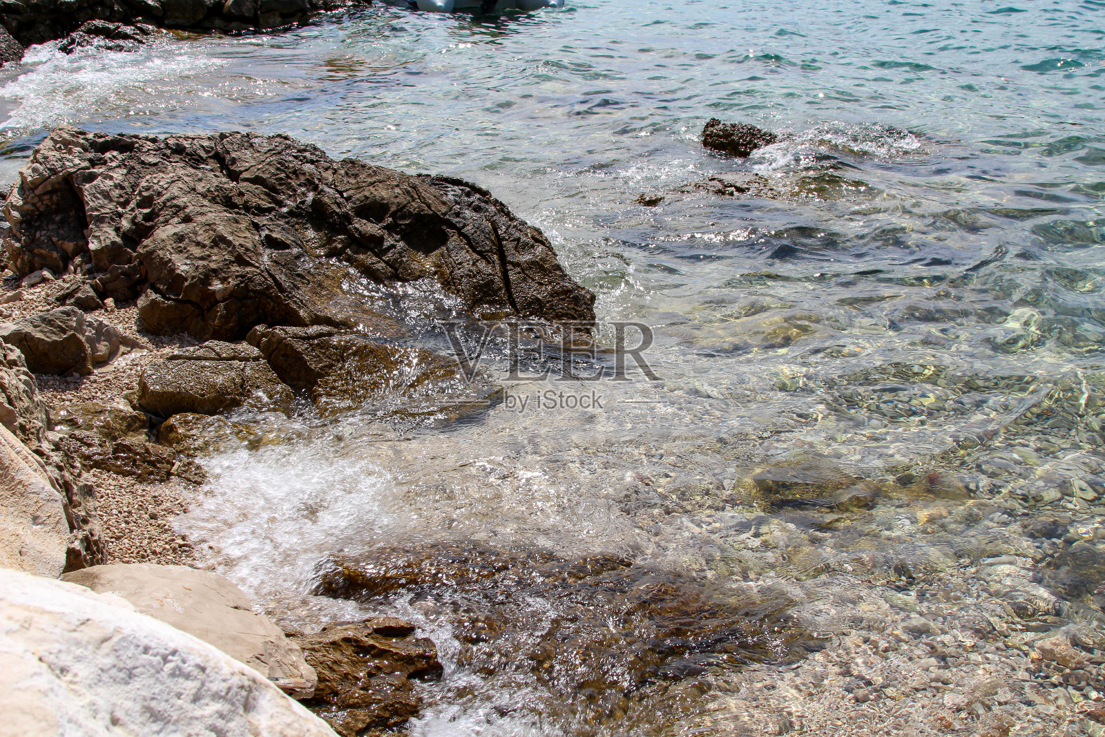 蓝色的地中海。清水。地中海海底的石头。小波。照片摄影图片