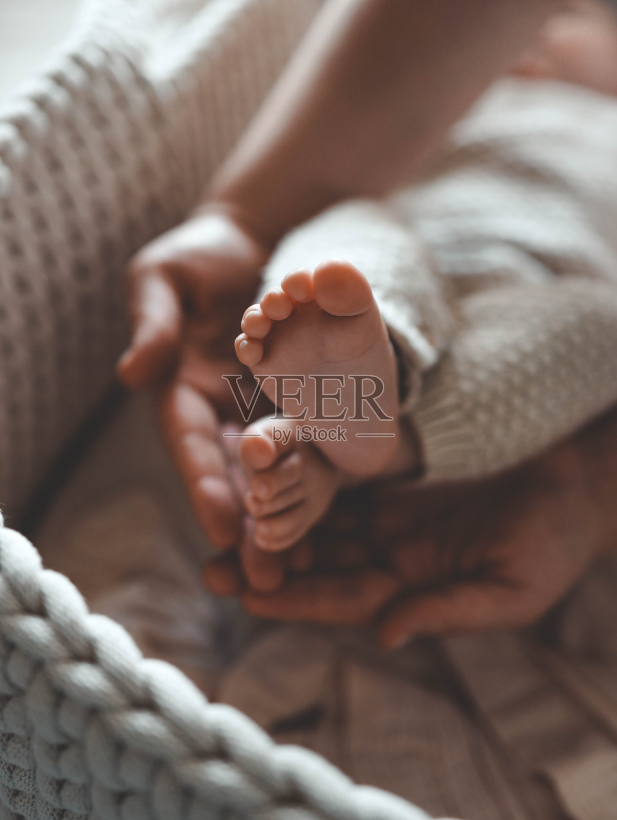 新生儿在妈妈手中的小双腿,母性和关爱的概念照片摄影图片