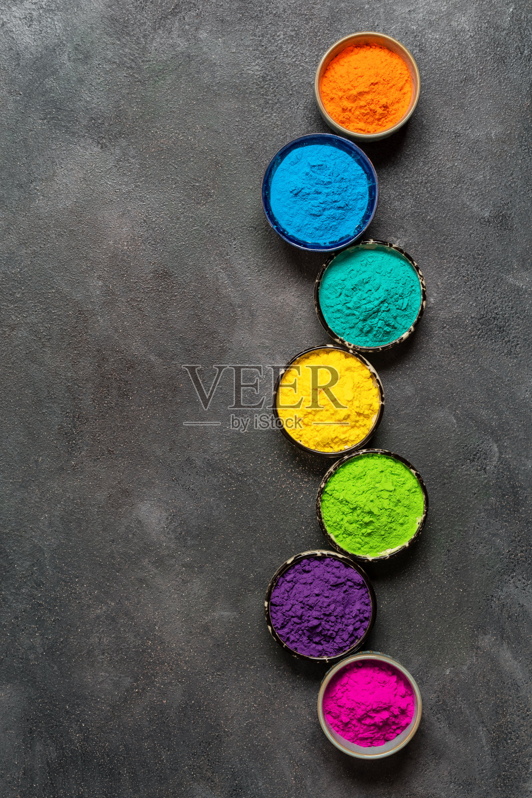 五颜六色的holi粉末装在碗里,垂直的边框。俯视图,平铺。有机古拉尔色照片摄影图片