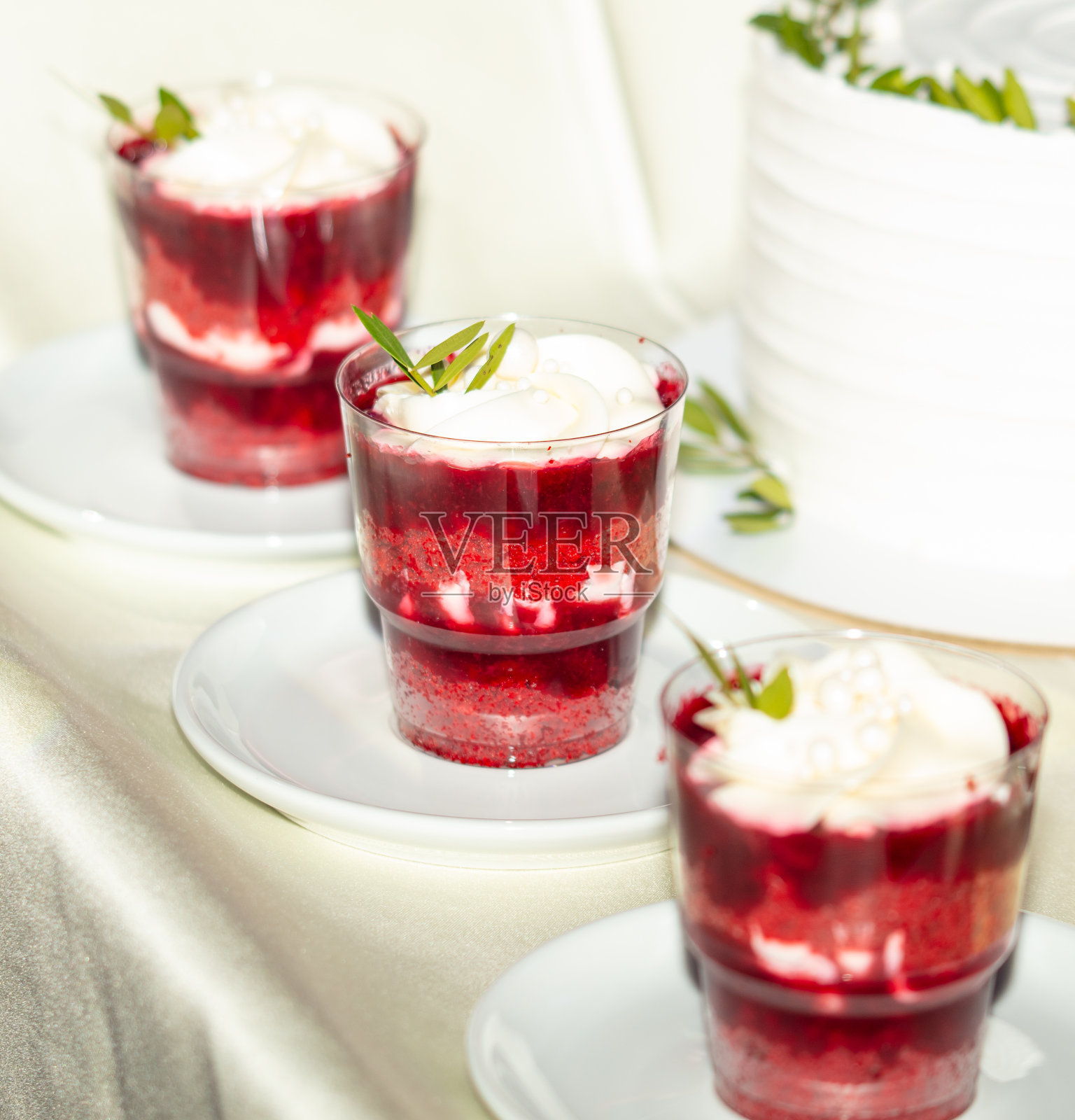 樱桃甜点,鲜奶油和薄荷装在桌子上的小杯子里照片摄影图片