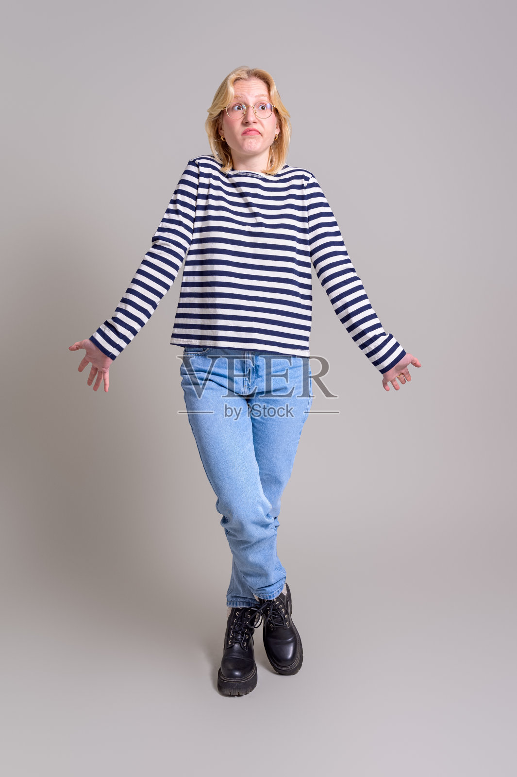 困惑的女商人耸着肩膀站在白色背景前照片摄影图片