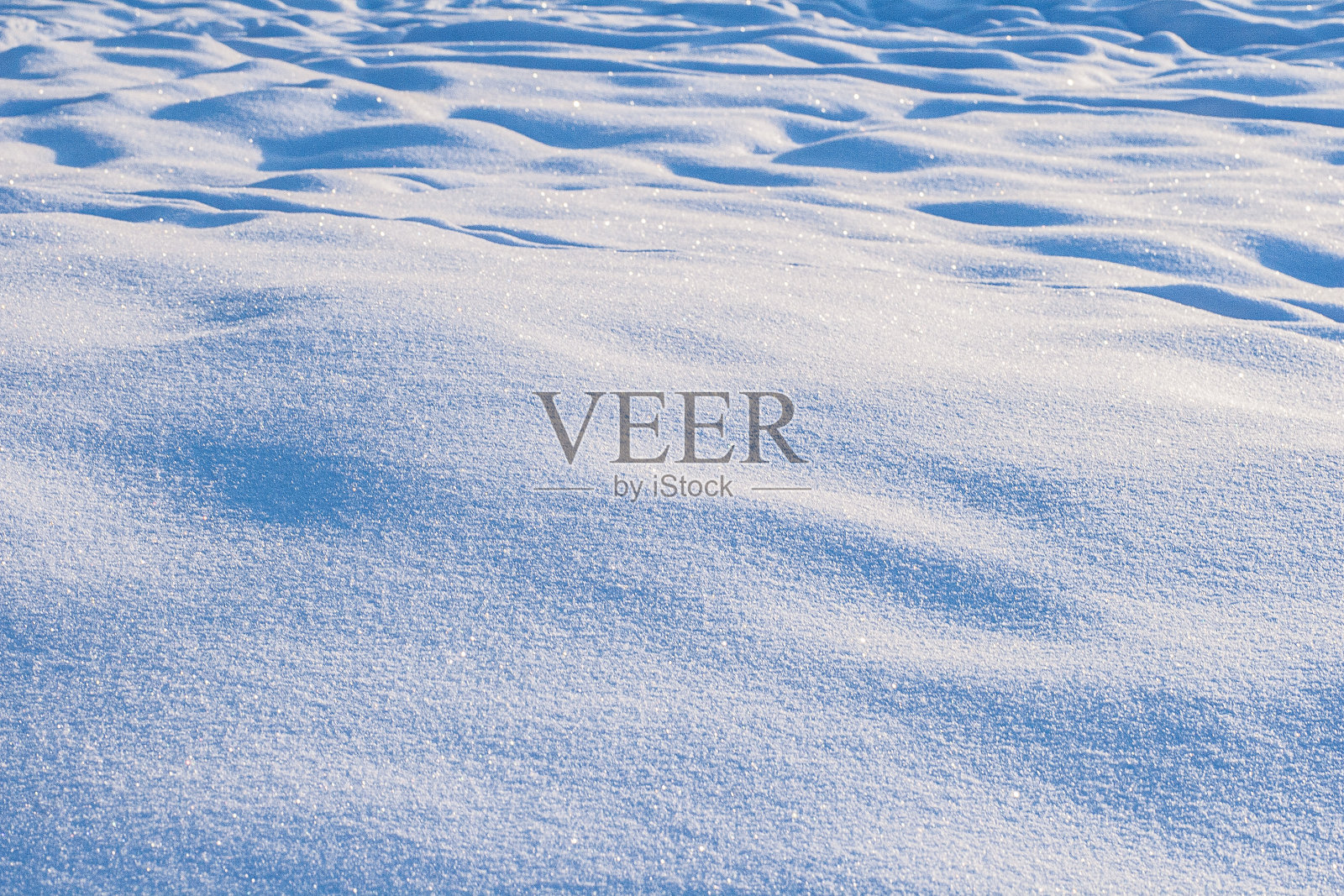 白天晴朗天气下的新鲜雪面。照片摄影图片