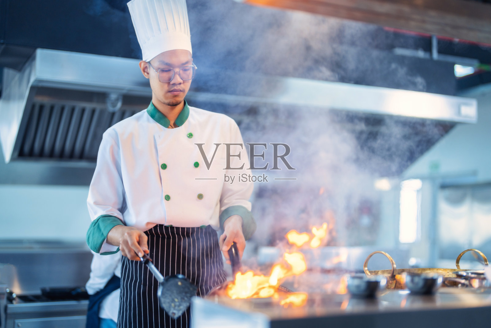 餐厅厨房的厨师在炉子和平底锅上烹饪食物照片摄影图片