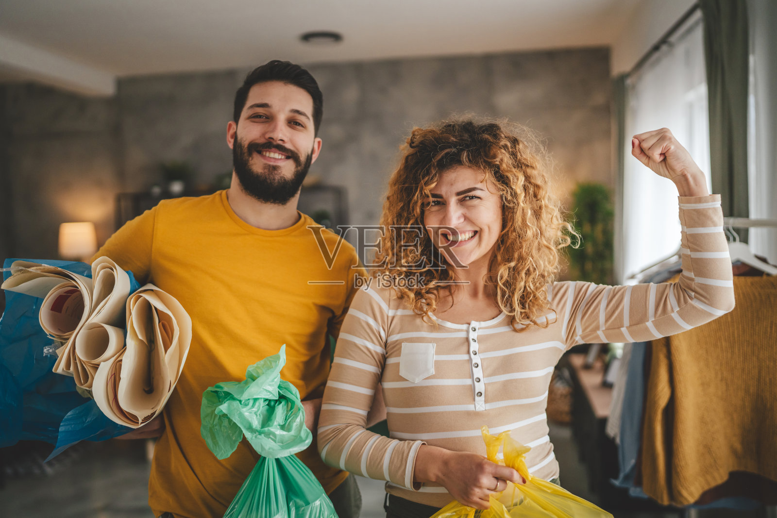 夫妻俩在家里分类回收废旧塑料、废纸和玻璃照片摄影图片