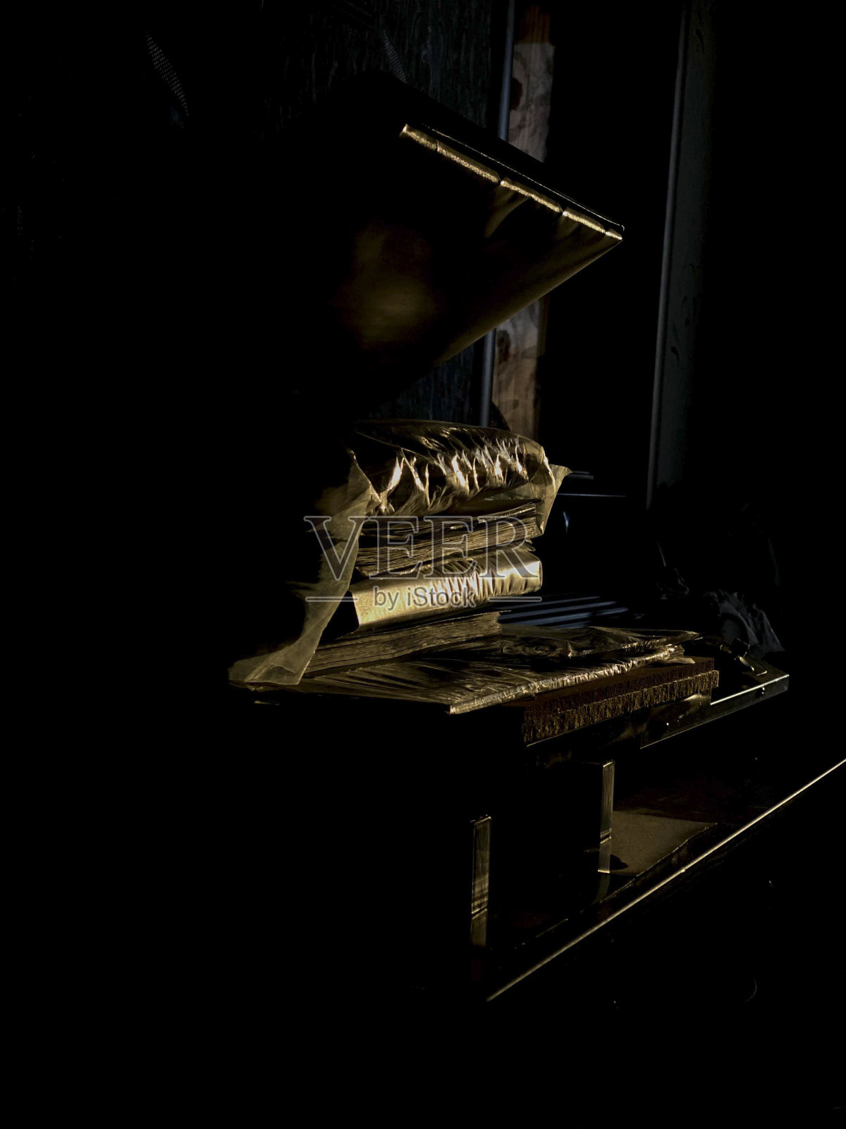 在一个黑暗的房间里,桌子上有一本旧书。有选择性的重点。照片摄影图片