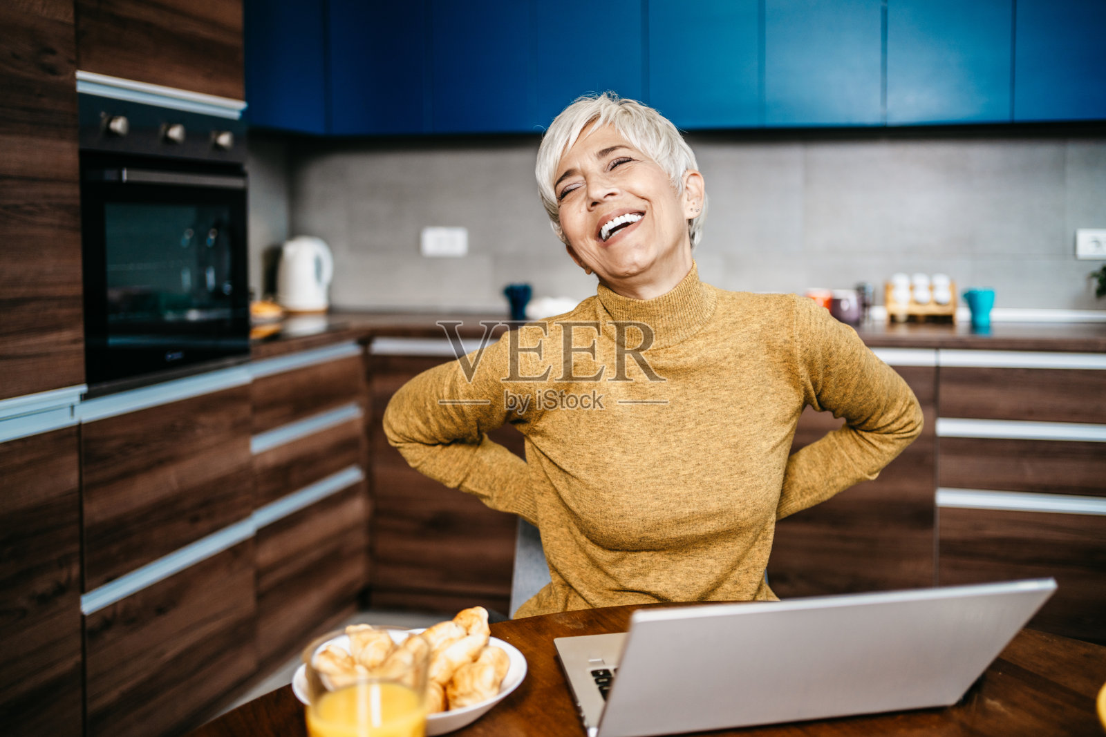 快乐的年长的女性在家工作照片摄影图片