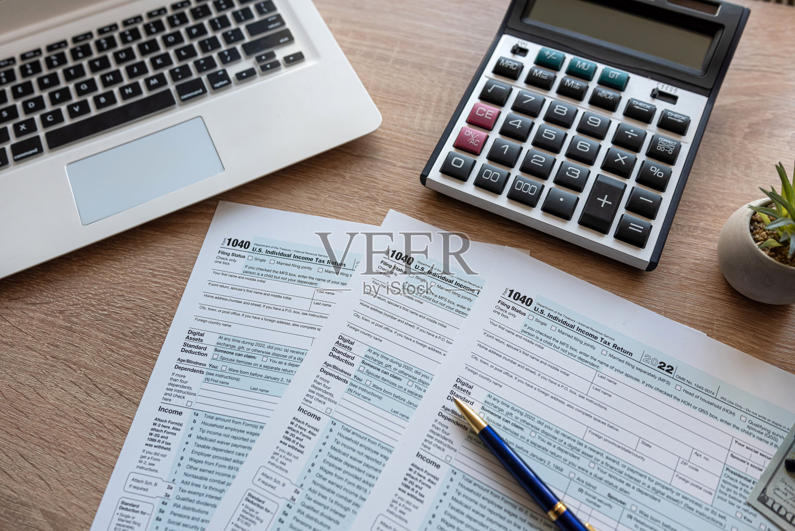 办公桌上有笔式笔记本电脑和眼镜的1040税表俯视图照片摄影图片