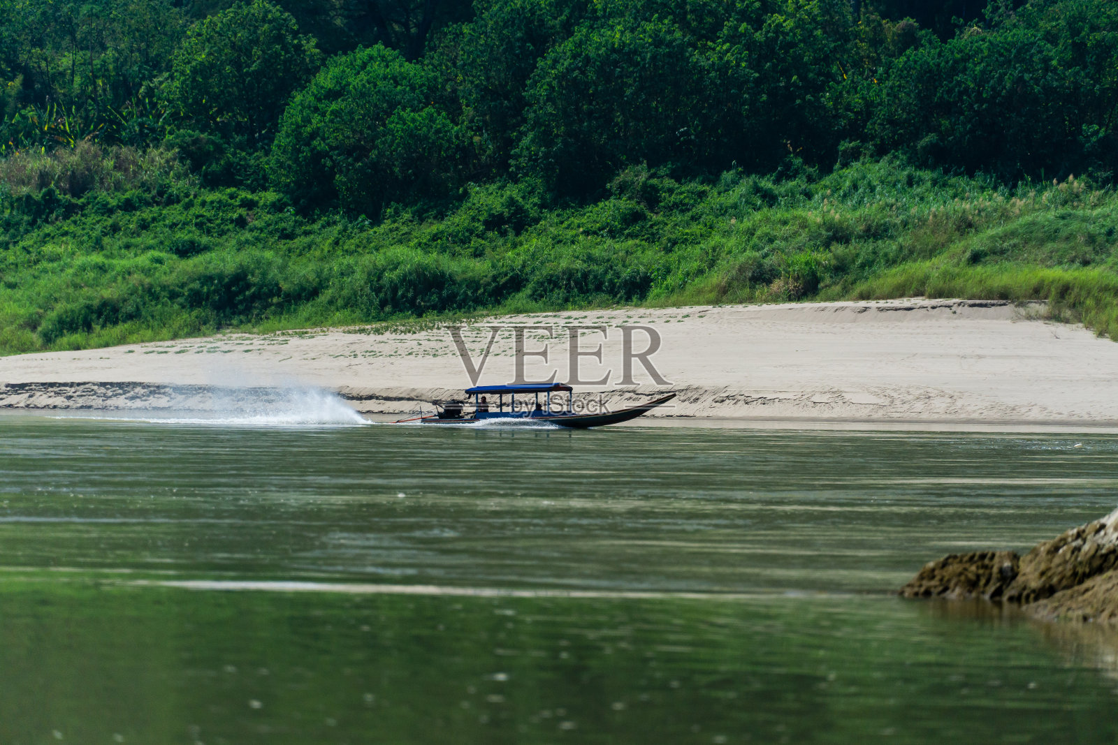 一艘长尾船经过。照片摄影图片