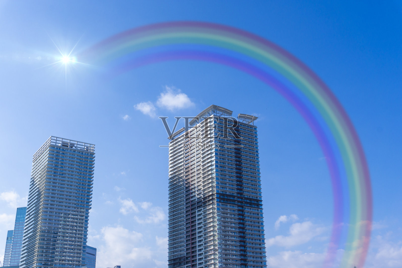 蓝天上的彩虹和高层公寓照片摄影图片