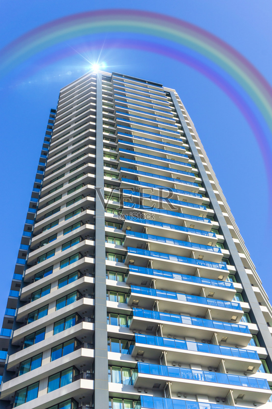 蓝天上的彩虹和高层公寓照片摄影图片
